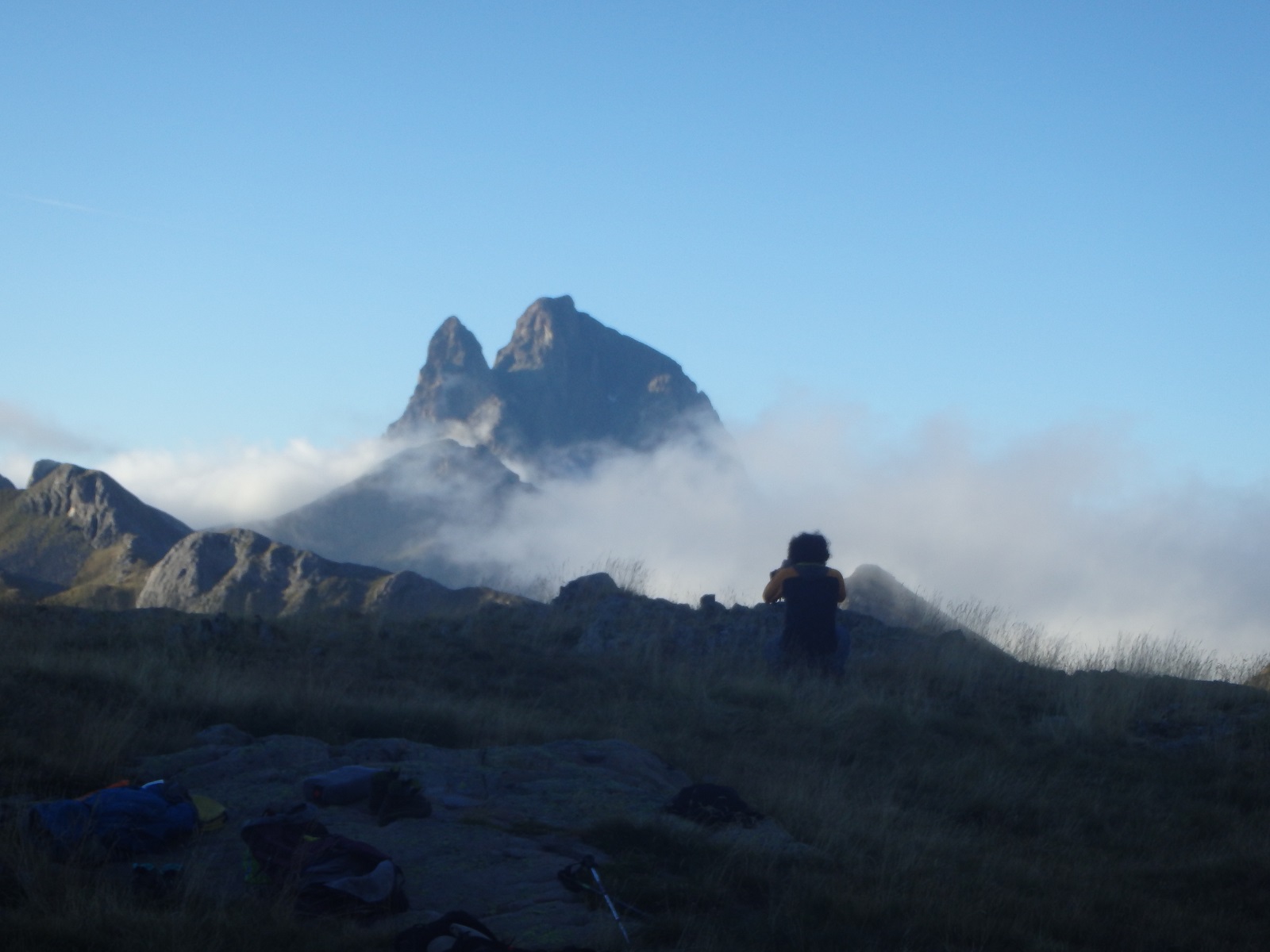 Photo de Faustin prenant des photos. Il se découpe devant le Pic du Midi d'Ossau, qui sort des nuages.